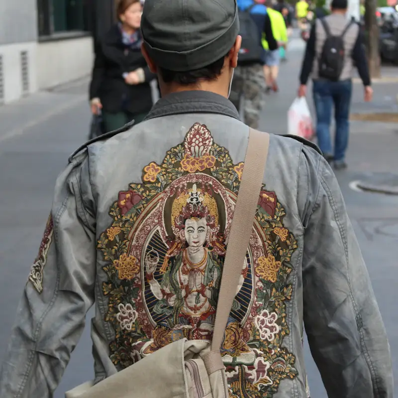 Large embroidered artwork on the back of a denim jacket