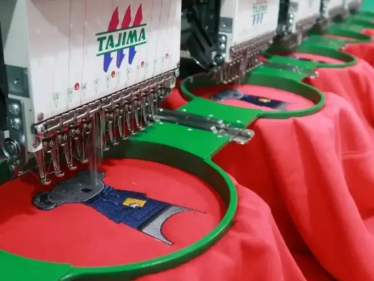 Embroidery machine stitching a logo after raster to vector conversion