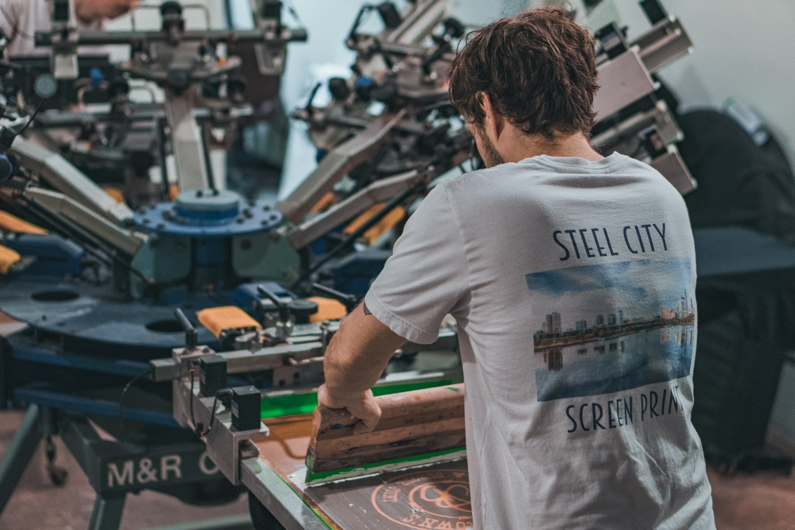 Screen printer running a press with print-ready vector artwork